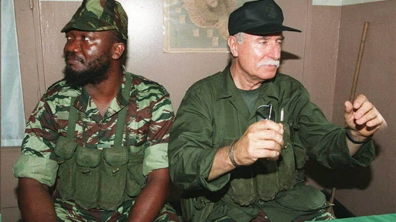 French mercenary Bob Denard (R) and rebel Captain Ayouba Combo speak to the press 04 October after French troops stormed Comoros early 04 October. French special troops mounted the operation to end a rebellion of mercenaries against the Comorian government.         AFP PHOTO